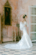 Woman wearing Monique Lhuillier Fall 2022 white fitted floral organza Delilah gown with billowing Delilah jacket