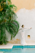 Woman wearing Monique Lhuillier Fall 2022 white sheer tulle floral embroidered Pearl corset, sheath skirt and peplum shirt