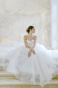 Woman wearing Monique Lhuillier Fall 2022 soft blush tulle draped Dream ball gown
