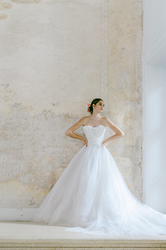 Woman wearing Monique Lhuillier Fall 2022 soft blush tulle draped Dream ball gown