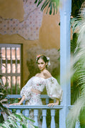Woman wearing Monique Lhuillier Fall 2022 fitted ivory and floral print Amalia gown with billowed sleeve