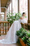 Woman wearing Monique Lhuillier Fall 2022 white floral organza Fernanda ballgown with matching billowed Fernanda sleeves
