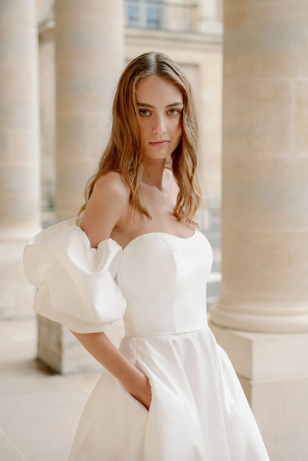Woman wearing Monique Lhuillier Fall 2023 Bliss white strapless sweetheart BL23201 ballgown with tufted sleeves