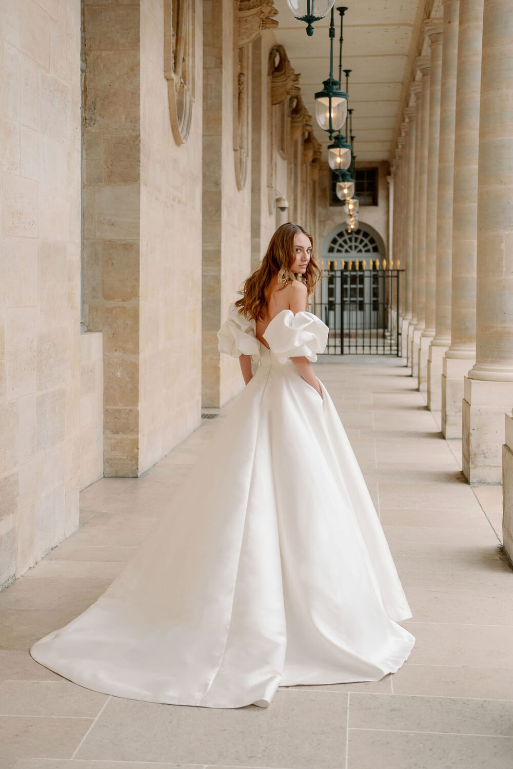 Woman wearing Monique Lhuillier Fall 2023 Bliss white strapless sweetheart BL23201 ballgown with tufted sleeves