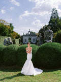 Woman wearing Monique Lhuillier Fall 2024 white fitted trumpet strapless Estelle gown