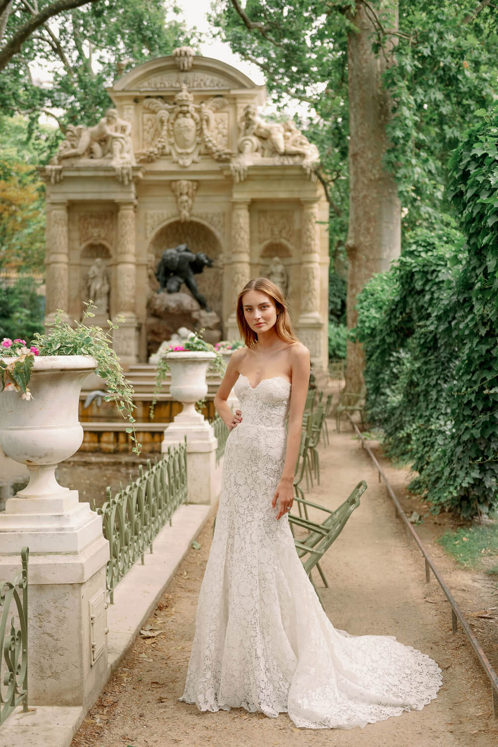 Woman wearing Monique Lhuillier Fall 2023 Bliss white lace strapless sweetheart fitted BL23202 gown with long train