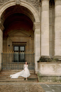 Woman wearing Monique Lhuillier Fall 2023 Bliss long sleeve v-neck white embroidered tulle a-line BL23203 gown