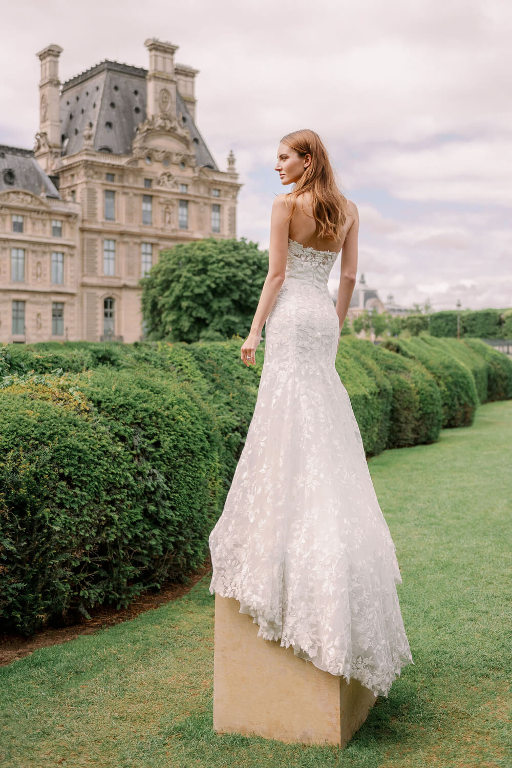 Woman wearing Monique Lhuillier Spring 2024 Bliss white embroidered lace BL24013 trumpet gown