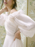 Woman wearing off-the-shoulder silk organza blush Monique Lhuillier Fall 2021 Ambrosia gown with billowed sleeve