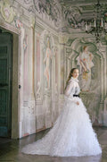 Woman wearing Monique Lhuillier Spring 2022 white blouse, black corset, black belt and white feather ball skirt, styles 22236, 22237, 22238
