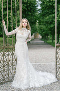 Woman wearing Monique Lhuillier Spring 2022 fitted white embroidered Mae scoop neck gown with matching long sleeve embroidered jacket