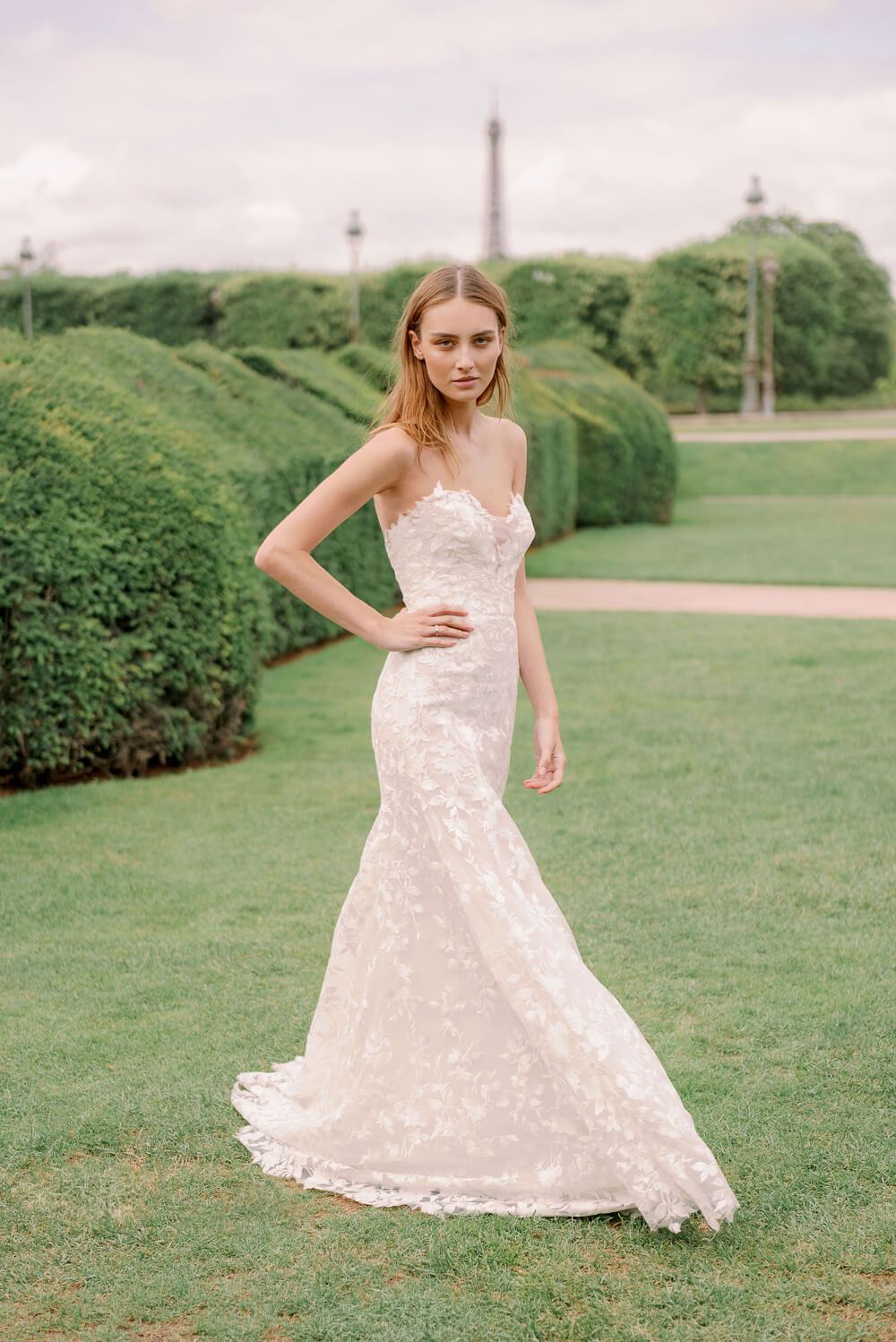 Woman wearing Monique Lhuillier Spring 2024 Bliss white embroidered lace BL24013 trumpet gown