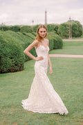 Woman wearing Monique Lhuillier Spring 2024 Bliss white embroidered lace BL24013 trumpet gown