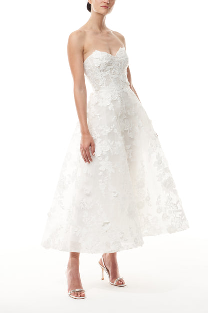 Monique Lhuillier Fall 2024 tea-length, strapless dress in silk white3D lace with full skirt and fitted sweetheart bodice - side.
