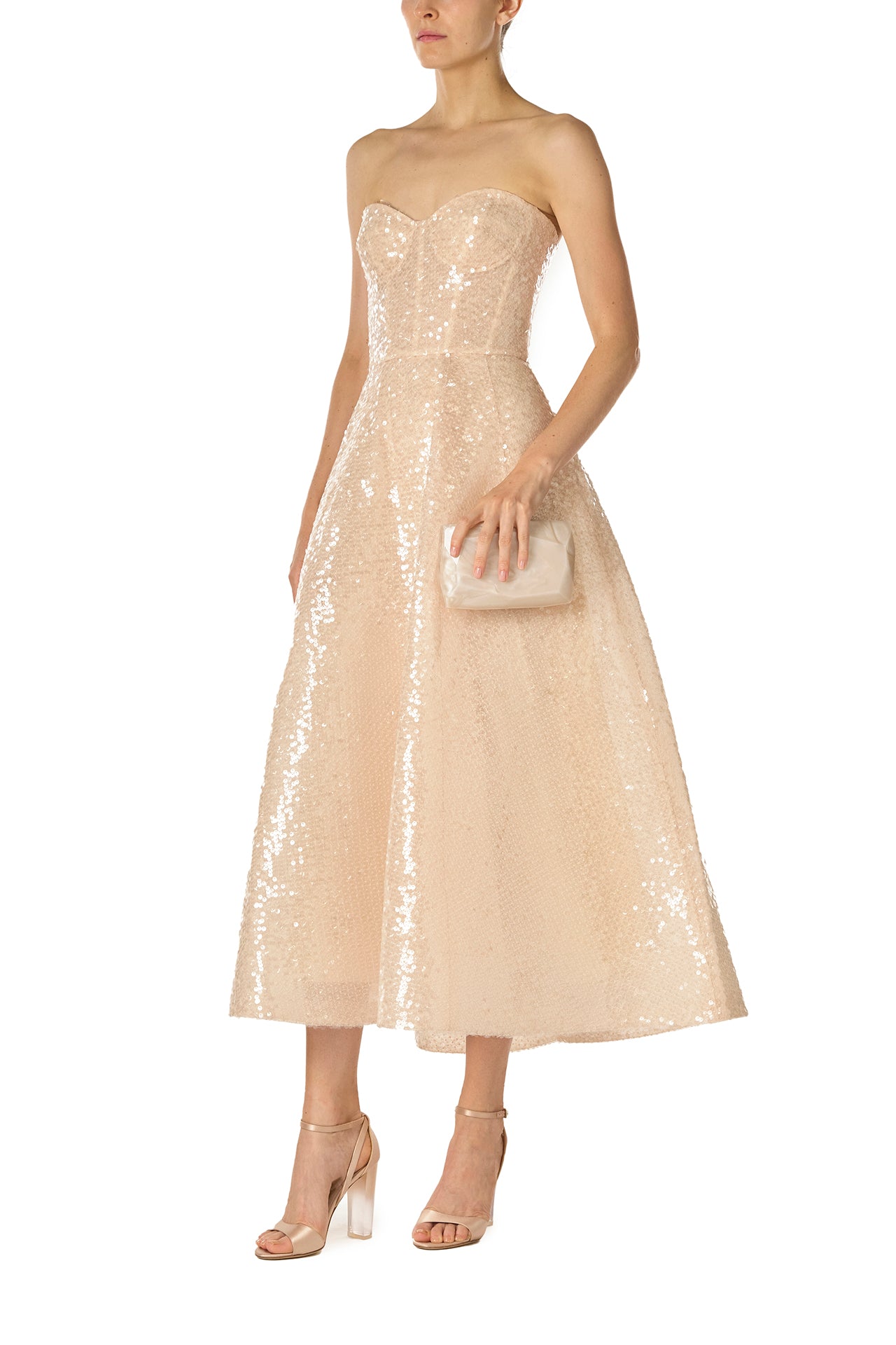 Monique Lhuillier Spring 2025 strapless, tea-length dress with sweetheart neckline in prosecco colored sequins - side with Dasha handbag in pearl.
