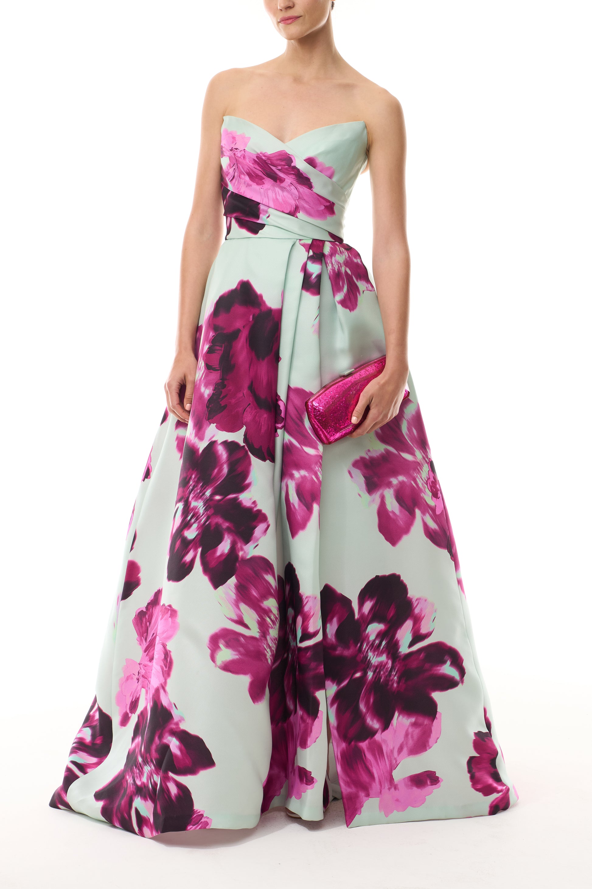 Monique Lhuillier Fall 2025 strapless ballgown with high leg slit and pockets in electric floral printed gazar - front with Viv clutch.