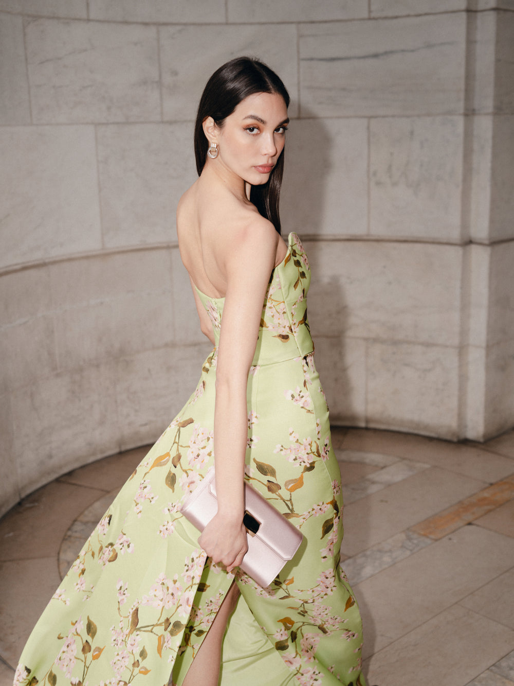 Monique Lhuillier Fall 2025  Draped Bodice Column Gown with Train in Celedon/Multi Wisteria Printed Gazar - lookbook photo with Pink Delphine clutch.