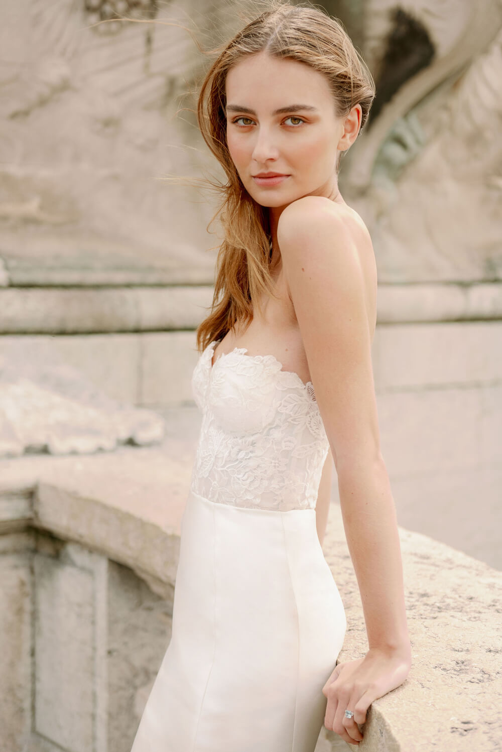 Woman wearing Monique Lhuillier Spring 2024 Bliss white embroidered lace and mikado BL24014 trumpet gown