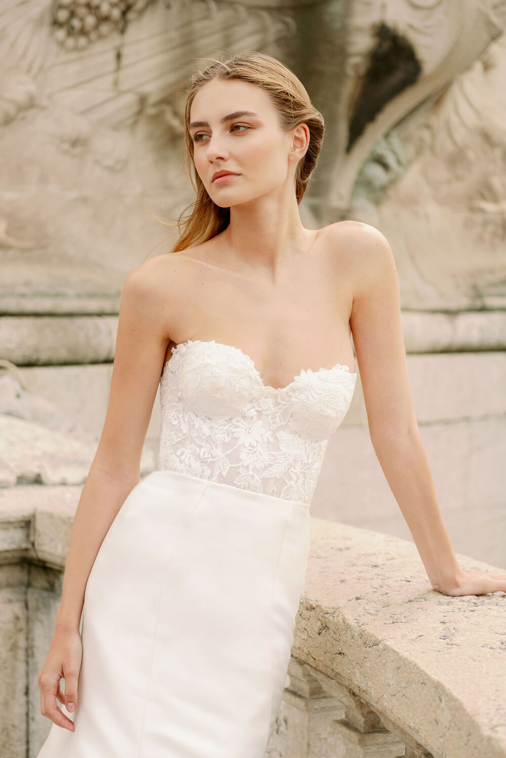Woman wearing Monique Lhuillier Spring 2024 Bliss white embroidered lace and mikado BL24014 trumpet gown