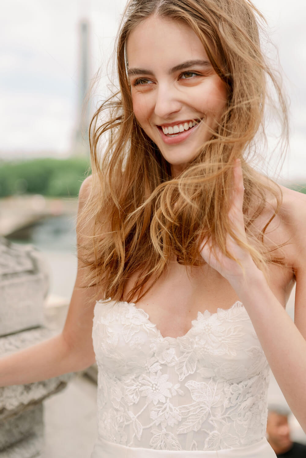 Woman wearing Monique Lhuillier Spring 2024 Bliss white embroidered lace and mikado BL24014 trumpet gown