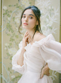 Woman wearing off-the-shoulder silk organza blush Monique Lhuillier Fall 2021 Ambrosia gown with billowed sleeve
