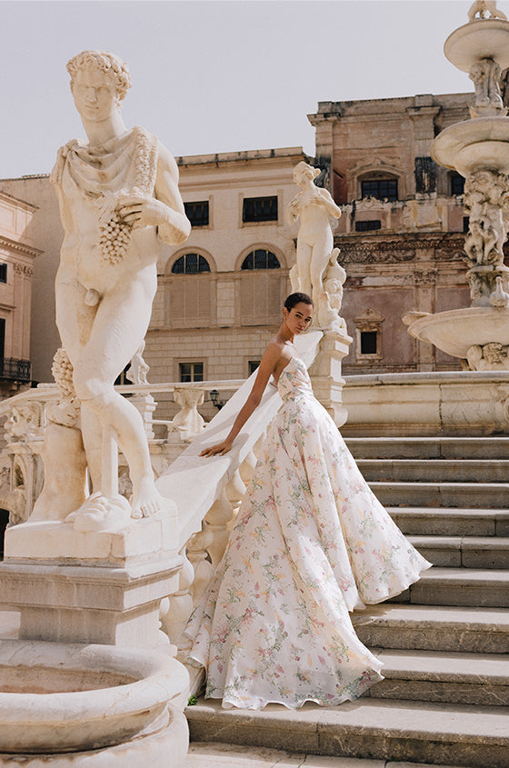 Woman wearing Monique Lhuillier Spring 2023 Bliss white and multi colored floral print strapless organza BL23102 ballgown