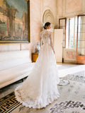 Woman wearing Monique Lhuillier Fall 2024 white Melrose lace bralette with lace long-sleeve high neck jacket and lace a-line skirt with slit