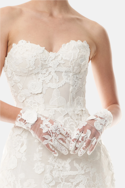 Silk white lace wristlet gloves shown with a lace strapless dress.