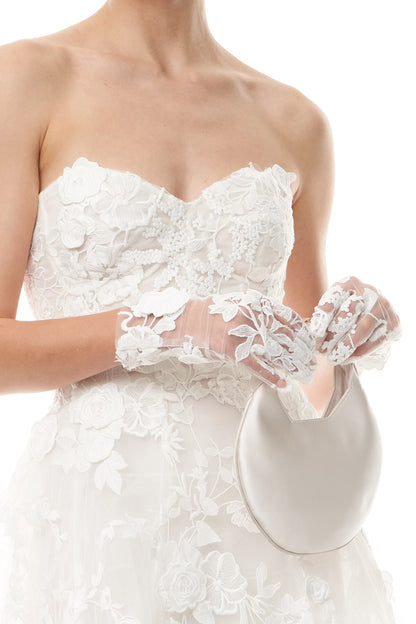 Silk white lace wristlet gloves shown with a lace strapless dress.