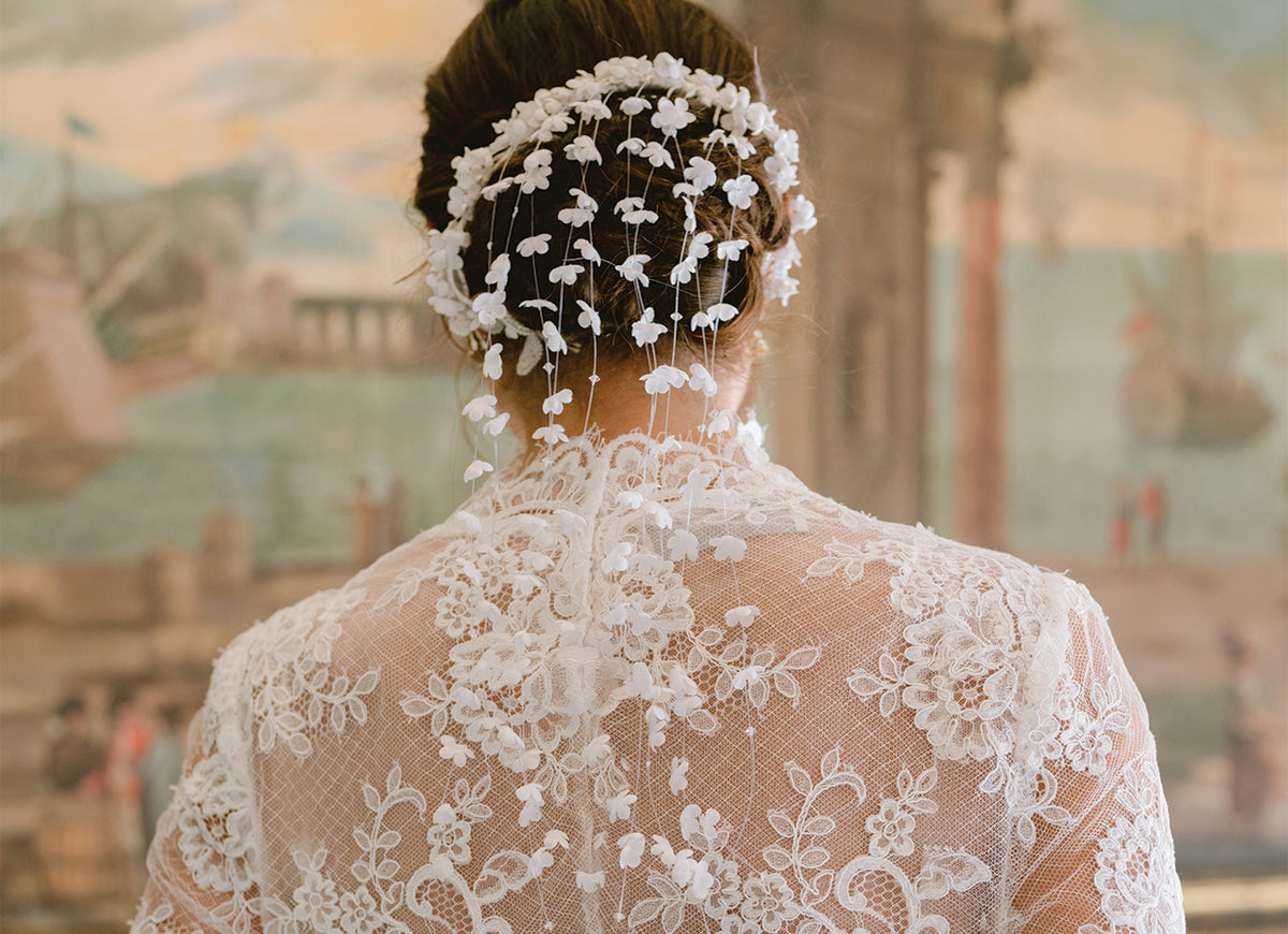 Model Wearing Monique Lhuillier Fall 2024 high neck long sleeve lace Melrose jacket with floral hair accessory
