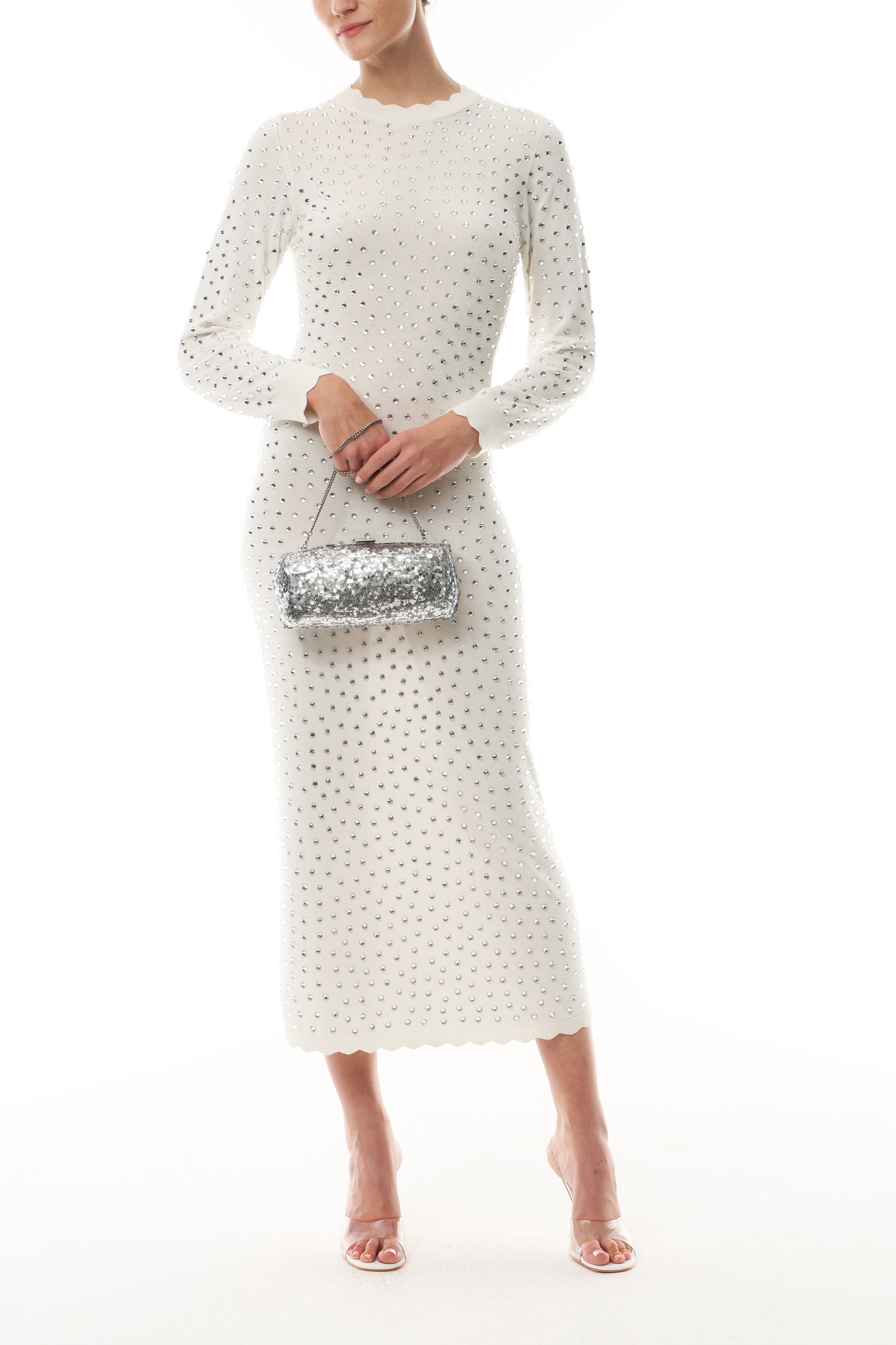 Monique Lhuillier Fall 2025 Ivory/silver Long sleeve cotton hotfix knit dress- front with Silverstar Viv clutch.