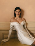 Woman wearing white mikado corseted off-the-shoulder Monique Lhuillier Spring 2023 Marisa cocktail dress with white opera-length gloves