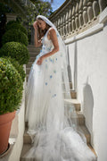 Woman wearing white tulle a-line Monique Lhuillier Spring 2021 Oceana gown with blue floral 3-D embroidery and matching veil