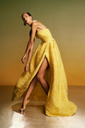 Monique Lhuillier Spring 2026 lookbook image - model wearing Buttercup Botanical Matelassé strapless draped gown with slit