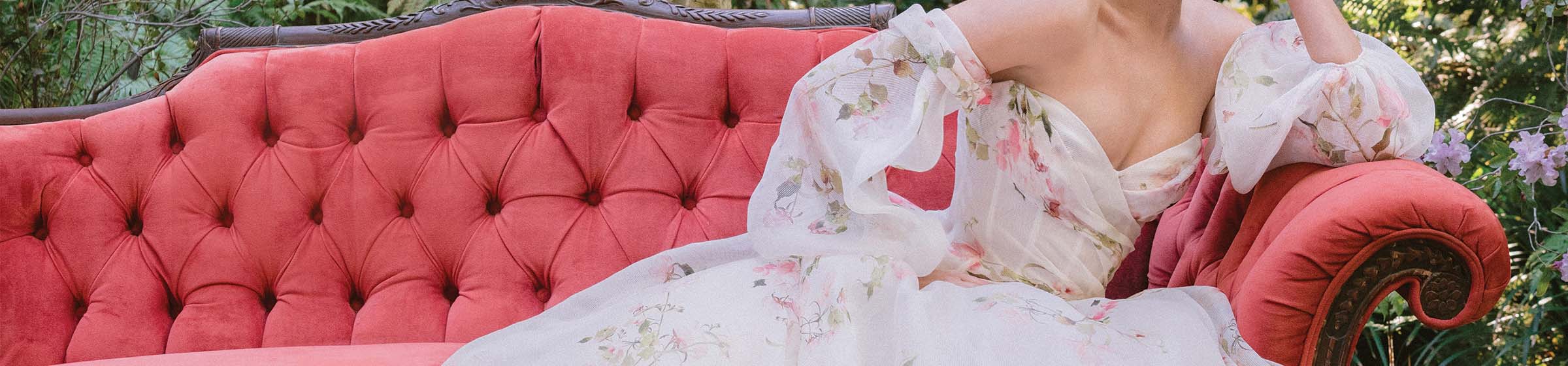 Woman wearing Monique Lhuillier Spring 2024 dropped waist white and floral printed Barrington draped ballgown and detachable billow sleeves