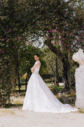 Woman wearing Monique Lhuillier Spring 2023 Bliss white strapless embroidered BL23105 ballgown with matching embroidered BL23170 jacket