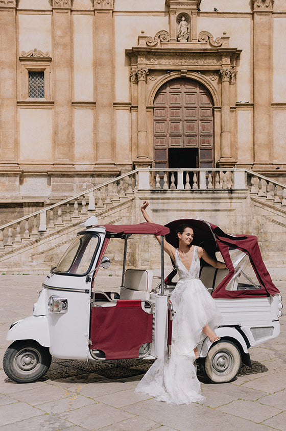 Woman wearing Monique Lhuillier Spring 2023 Bliss white and multi colored floral print v-neck trumpet tulle BL23110 gown