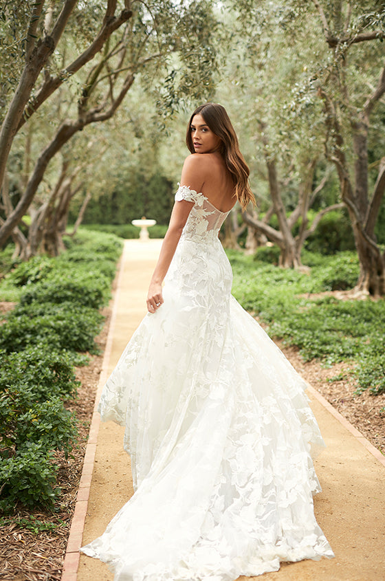 Woman walking in white embroidered off-the-shoulder modified a-line Monique Lhuillier Spring 2021 Celestina gown