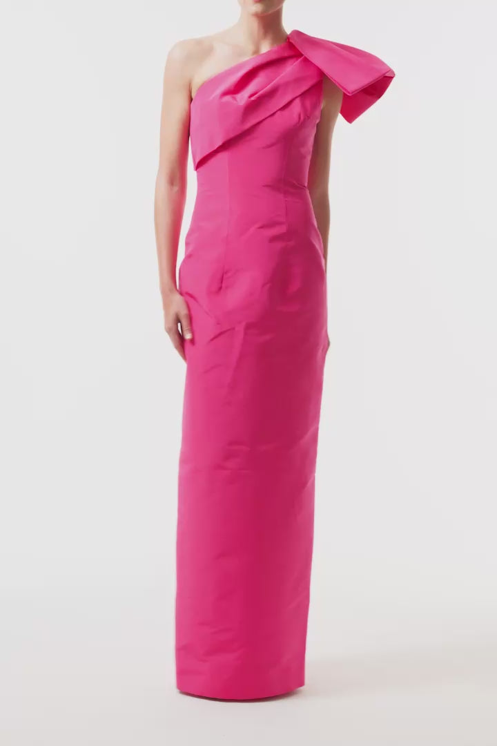Monique Lhuillier Spring 2025 One shoulder, draped column gown with bow detail in Hot Pink faille fabric - video.