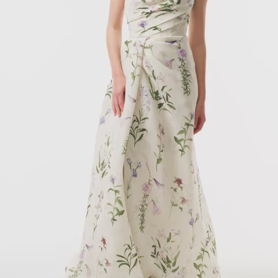 Monique Lhuillier Fall 2025 strapless, floor length gown with draped bodice and high leg slit in ivory floral multi printed gazar fabric - video.