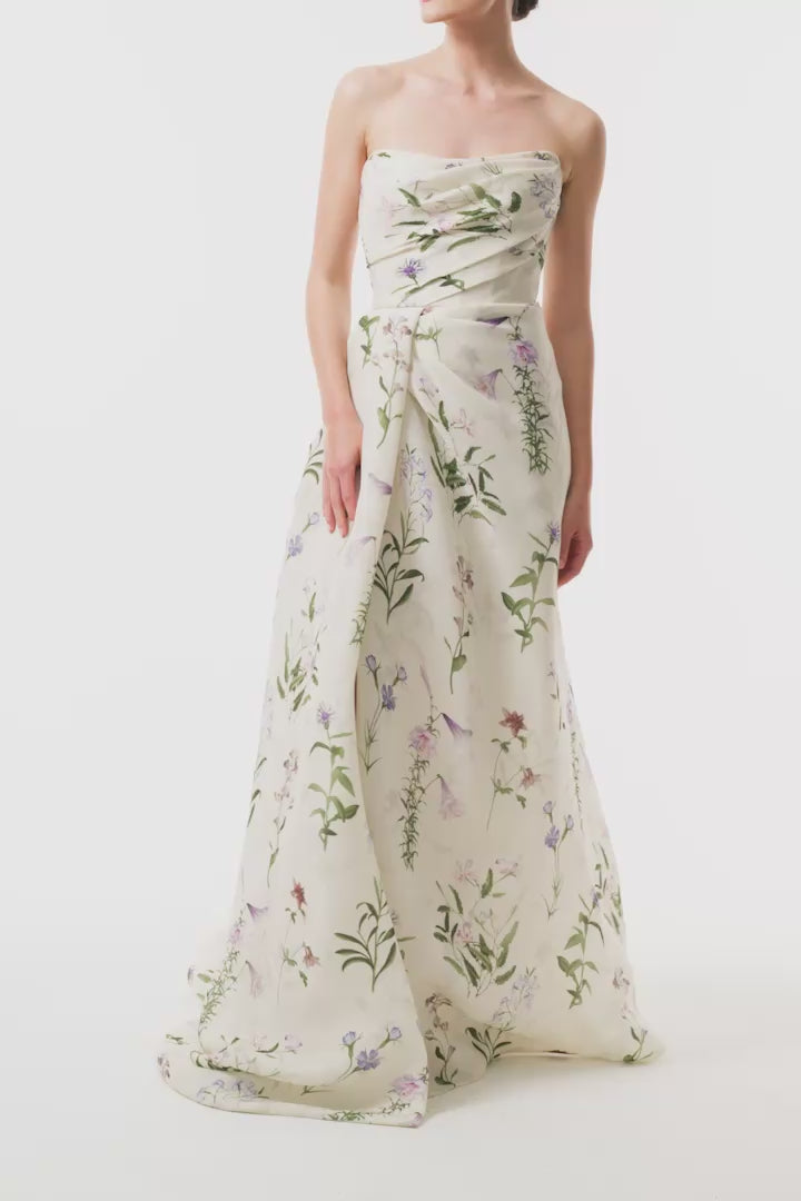 Monique Lhuillier Fall 2025 strapless, floor length gown with draped bodice and high leg slit in ivory floral multi printed gazar fabric - video.