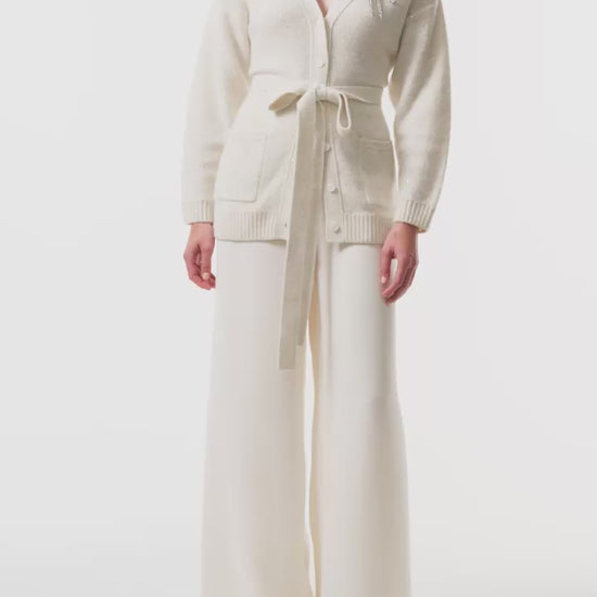Monique Lhuillier Fall 2025 long sleeve cardigan in ivory sequin cashmere with bow brooch and self-tie belt - video.