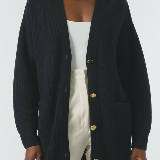 Monique Lhuillier Spring 2024 black chunky long cashmere cardigan with gold buttons - video.