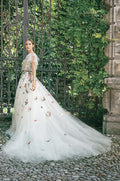 Woman wearing Monique Lhuillier Fall 2020 Wonder a-line gown with multi-colored floral embroidered tulle and ruffle detail at neckline